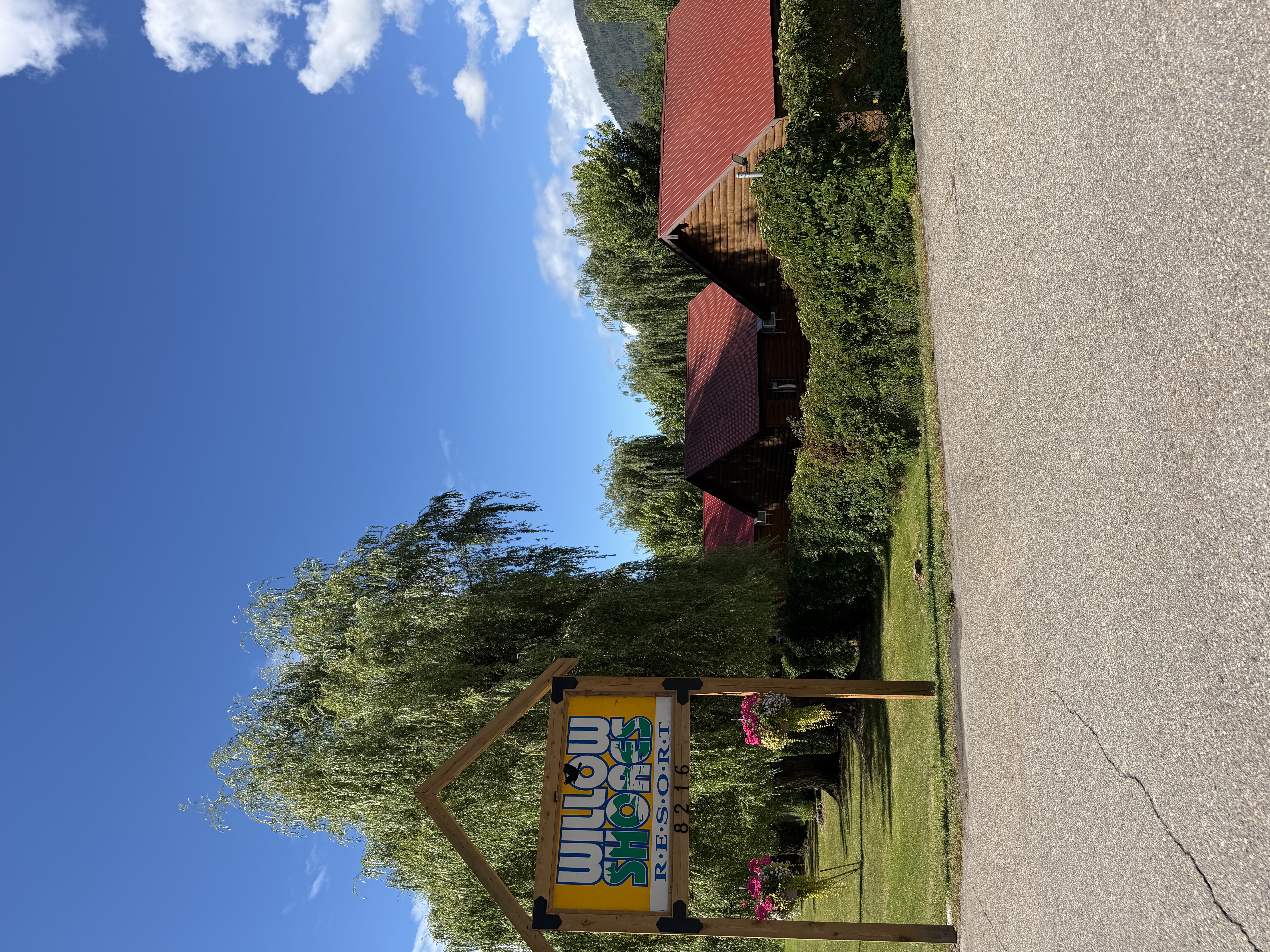 Willow Shores Resort welcome sign and cabins beneath a bright summer sky
